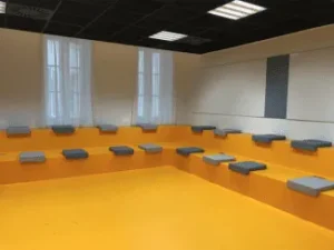 Banquette salle de conférence sol orange avec coussins gris