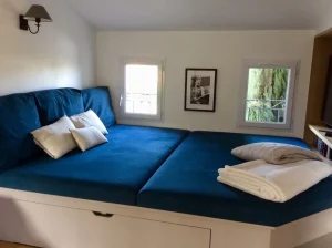 Lit de lecture bleu sous fenettre