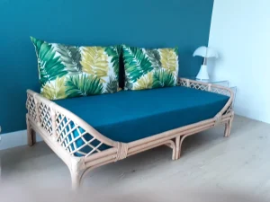 Canapé housse bleu avec coussins fleuris et contour en bois